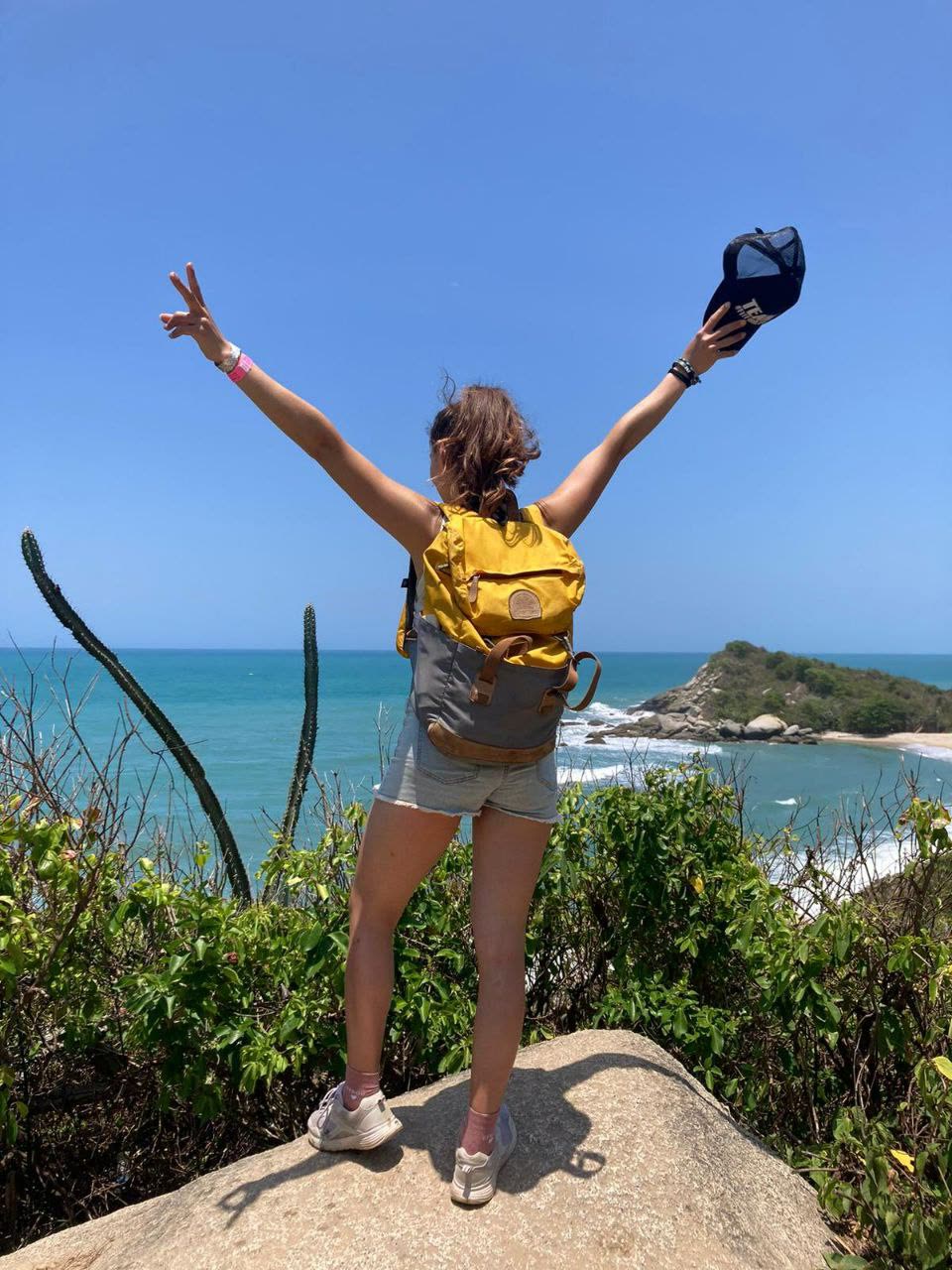 Alizée Baptiste, coach Sunrise Method, bras levés en V devant la mer